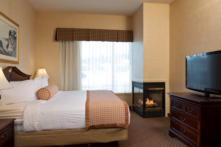Hotel room with bed and gas fireplace