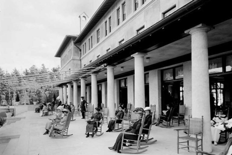 guest relaxing in rocking chairs at the Fort William Henry Hotel History Photo