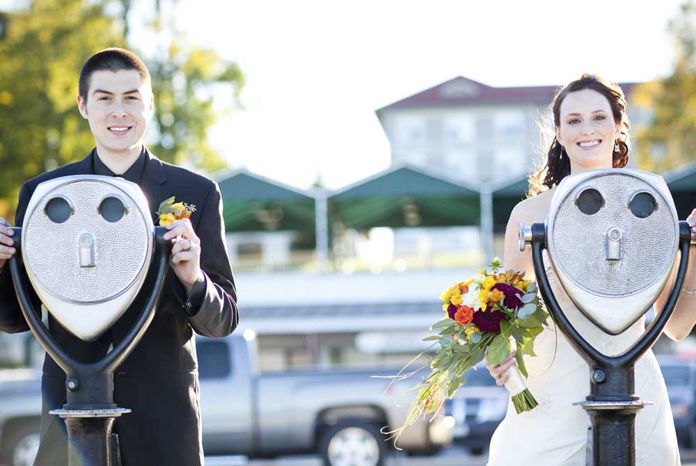 Couple posing for wedding photos with sight seeing binoculars