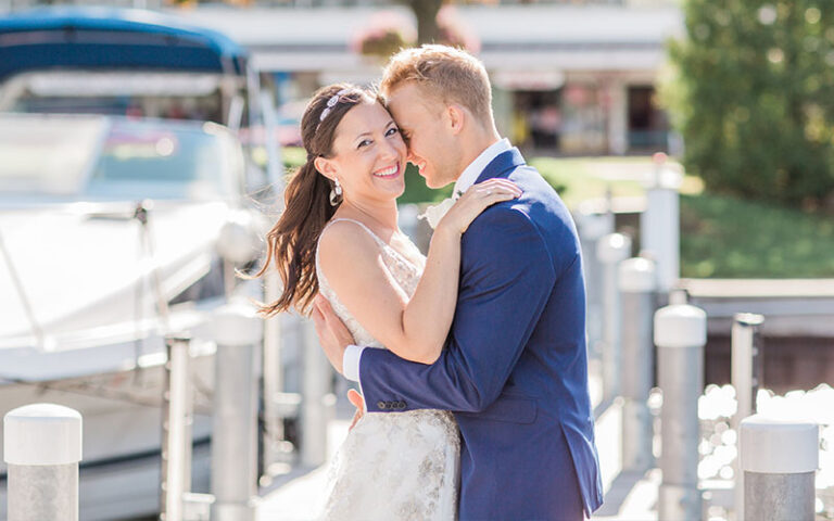 bride and groom embracing on a dock