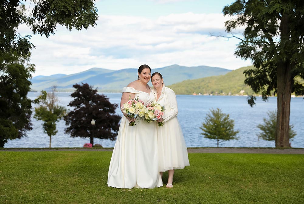 Wedding couple in wedding dresses in front of lake