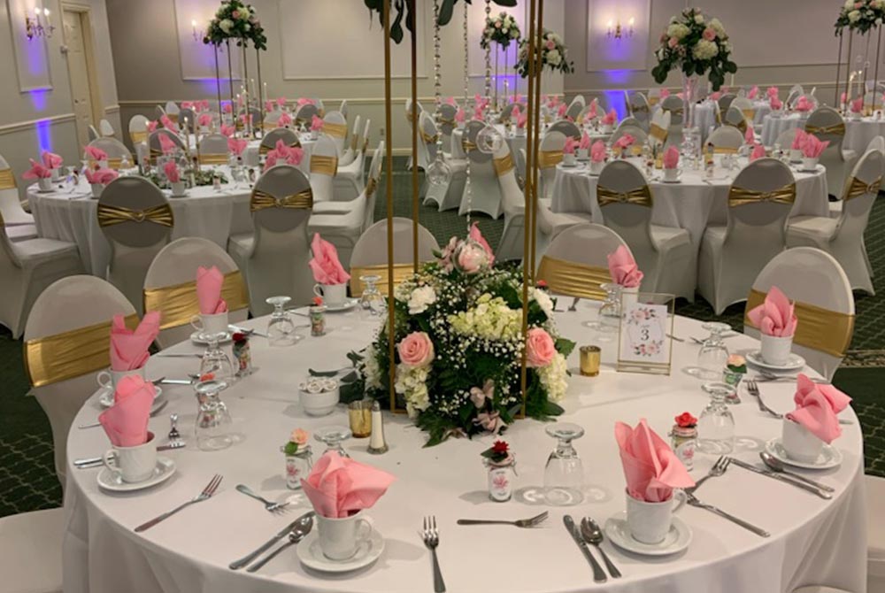 wedding ballroom with white linens on tables and chairs
