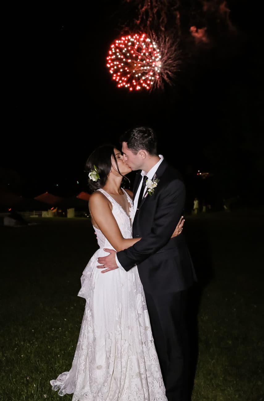 Bride and groom embracing under fireworks at night